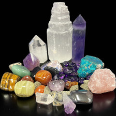 High‑quality gemstone carvings and crystal wands displayed together—skulls, palm stones, wand, and animal sculptures.