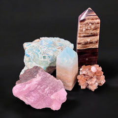 Assortment of Aragonite clusters and carvings on a ritual altar at Raven’s Cauldron, used for grounding and emotional healing.