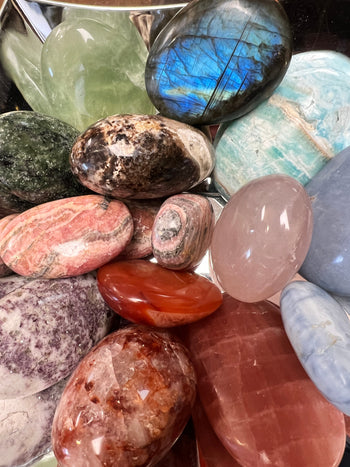 Colorful crystal display showcasing red, green, blue, and purple crystals at Raven’s Cauldron