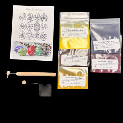 Egg dyeing kit with packaging, dyes, and tools on a black background