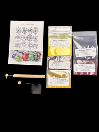 Egg dyeing kit with packaging, dyes, and tools on a black background