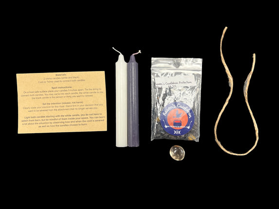 Raven's Cauldron Cord Cutting Ritual Kit with black and white candles, twine, Smoky Quartz tumble, Protection Blend Chips, and ritual guide