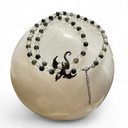 Beaded necklace with a dragon charm on a white background