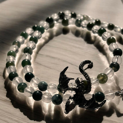 Beaded bracelet with a dragon charm on a wooden surface