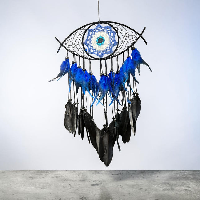 Large evil eye dreamcatcher with crocheted evil eye center and decorative feather details measuring 26 by 15 inches. Raven's Cauldron, 6 N Sandusky St, Delaware, OH 43015