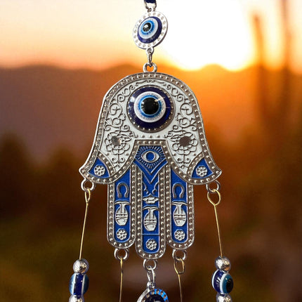Brass Evil Eye Wind Chimes with five bells and Hand of Hamsa design, measuring 17 inches in length, hanging against a neutral background.