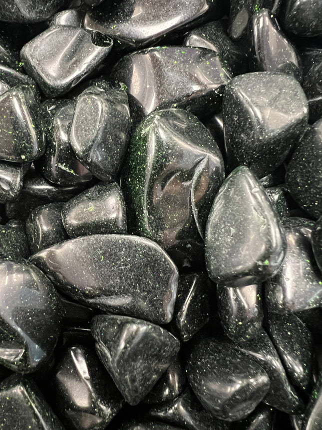 Green Goldstone tumbled stone with sparkling metallic flecks, polished finish, approximately 1 inch, photographed on a white background.