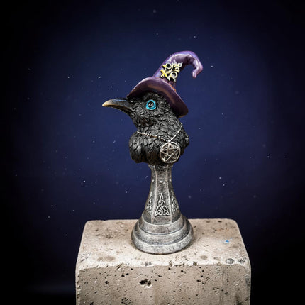 Raven Witch Statue wearing a purple witch's hat and pentagram necklace displayed on a silver stand, measuring 7 inches tall.