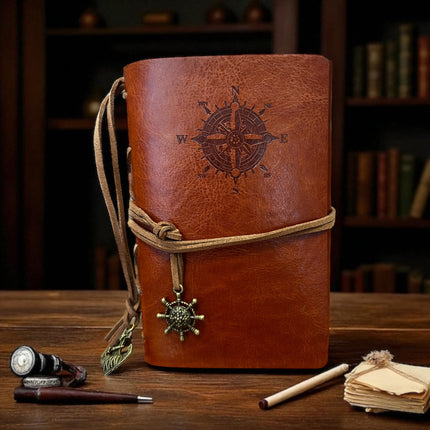Brown leather journal with compass design on a wooden surface Raven's Cauldron,  6 N. Sandusky St, Delaware, OH 43015