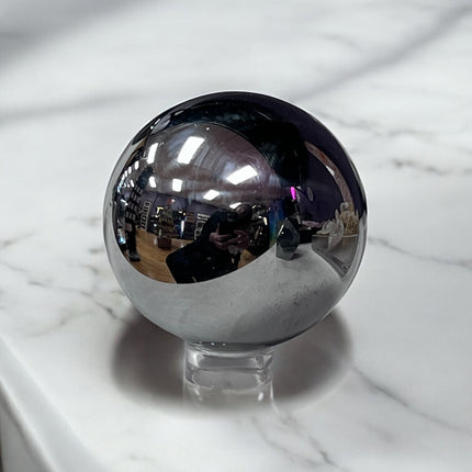 Silver metallic sphere on a marble surface terahertz sphere ,Ravens Cauldron, 6 N Sandusky St, Delaware, OH 43015