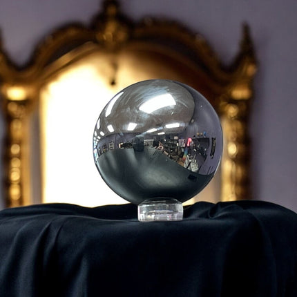Silver metallic sphere on a black surface with a reflective gold mirror in the background, terahertz sphere, Ravens Cauldron, 6 N Sandusky St, Delaware, OH 43015